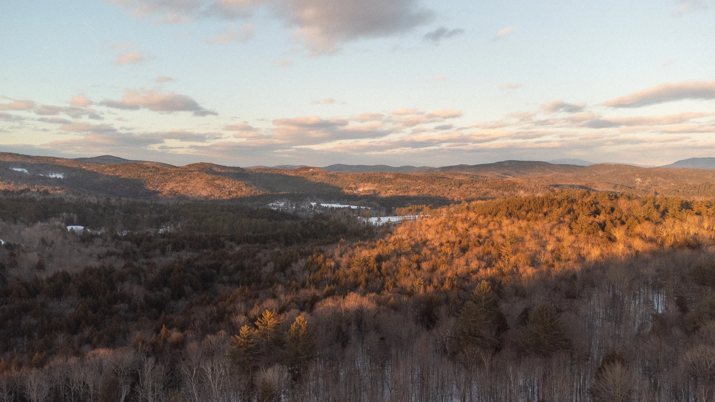 Warm evening sunlight across wooded Vermont hills